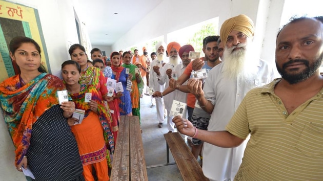 As Singh entered the polling station, a volunteer steered him in a wheelchair into the booth where he cast his vote, assisted by his son.(HT Photo)