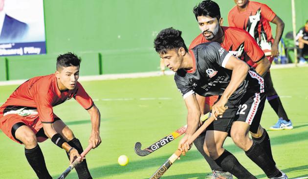 The players of Income Tax (black) and Vikram Pillay A-team in action, at the Major Dhyan Chand hockey poligras stadium, Nehrunagar, Pimpri, on Sunday.(HT PHOTO)