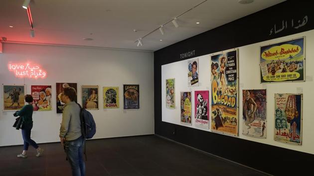 Visitors observe vintage cinema posters displayed at an art exhibition. Late Lebanese-American academic Jack Shaheen analysed portrayals of Arabs in Hollywood films. He watched more than 900 movies spanning a century to the early 2000s, and found only five percent showed Arab roles as “normal, human characters”. Instead, a whole people was systematically dehumanised or vilified and female characters were largely belly dancers or enchantresses, silent “bundles of black” or “terrorists”. (Joseph Eid /AFP) Visitors observe vintage cinema posters displayed at an art exhibition. Late Lebanese-American academic Jack Shaheen analysed portrayals of Arabs in Hollywood films. He watched more than 900 movies spanning a century to the early 2000s, and found only five percent showed Arab roles as “normal, human characters”. Instead, a whole people was systematically dehumanised or vilified and female characters were largely belly dancers or enchantresses, silent “bundles of black” or “terrorists”. (Joseph Eid /AFP)