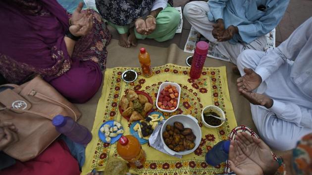 A family raises their hands to make Dua (prayer) before breaking their fast on the first day of the holy fasting month of Ramadan, at Jama Masjid, in New Delhi. (Burhaan Kinu/HT Photo) A family raises their hands to make Dua (prayer) before breaking their fast on the first day of the holy fasting month of Ramadan, at Jama Masjid, in New Delhi. (Burhaan Kinu/HT Photo)