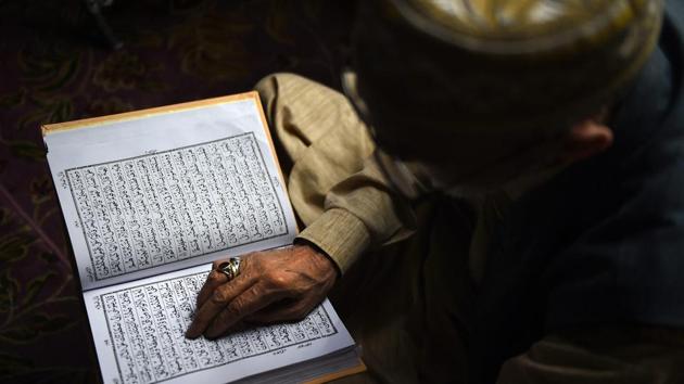 A devotee recites the holy book of Quran at a shrine on the third day of Ramadan month, in Srinagar. (S Irfan / PTI) A devotee recites the holy book of Quran at a shrine on the third day of Ramadan month, in Srinagar. (S Irfan / PTI)