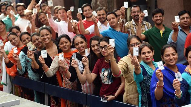 People show voter IDs before casting their vote, at RSKV School, West Vinod Nagar, in New Delhi, Ion Sunday, May 12, 2019.(Raj K Raj/HT PHOTO)