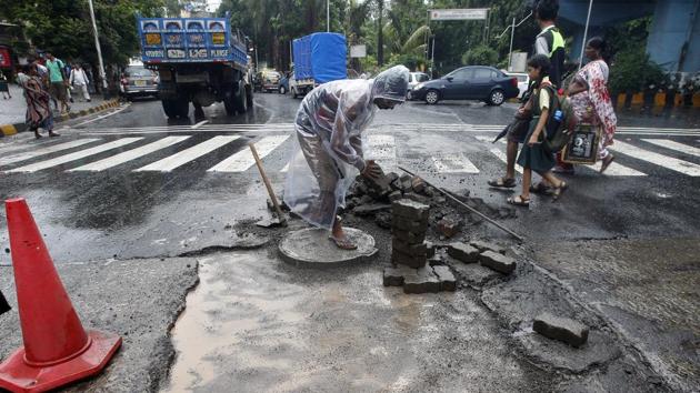 An MMRDA worker fills potholes at Sion in Mumbai.(HT FILE) An MMRDA worker fills potholes at Sion in Mumbai.(HT FILE)