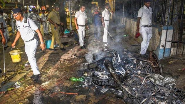 Police personnel douse burning vehicles caused by a mob during BJP President Amit Shah's election roadshow for the last phase of Lok Sabha polls, in Kolkata, Tuesday, May 14, 2019.(PTI photo)