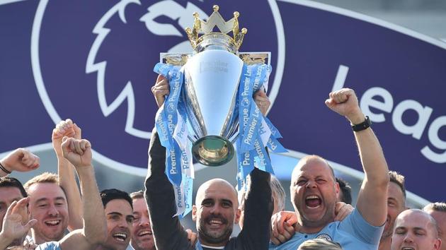 Manchester City's Spanish manager Pep Guardiola holds up the Premier League trophy as he's surrounded by his staff after their 4-1 victory in the English Premier League football match between Brighton and Hove Albion and Manchester City(AFP) Manchester City's Spanish manager Pep Guardiola holds up the Premier League trophy as he's surrounded by his staff after their 4-1 victory in the English Premier League football match between Brighton and Hove Albion and Manchester City(AFP)