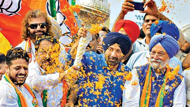 BJP's candidate from Gurdaspur Sunny Deol with BJP’s Amritsar candidate and union minister Hardeep Singh Puri during an election roadshow in Amritsar on Thursday.(PTI)