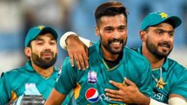 Pakistan's Hussain Talat (R) celebrates with Pakistan's Mohammad Amir (C) after taking during the third and final Twenty20 (T20) international cricket match between South Africa and Pakistan.(AFP)