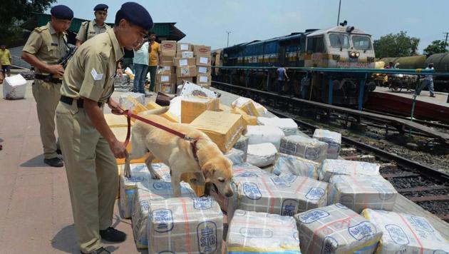 Security personnel with sniffer dogs inspect parceled goods, at Guwahati Railway station.(PTI)