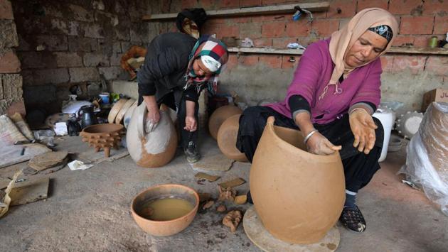 Seated in her lean-to overlooking the family lands, she scoops up the clay and spends most of her time fashioning utensils as well as stylised tortoises and horses. The women of Sejnane make and decorate their artisan pottery with natural elements from the agricultural region. (Fethi Belaid / AFP) 