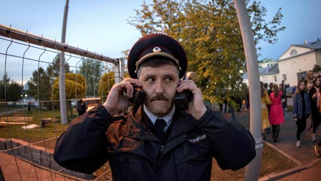 A police officer speaks on two walkie talkies during a protest against building a new cathedral, in a park in Yekaterinburg, Russia. (Anton Basanayev / AP) A police officer speaks on two walkie talkies during a protest against building a new cathedral, in a park in Yekaterinburg, Russia. (Anton Basanayev / AP)