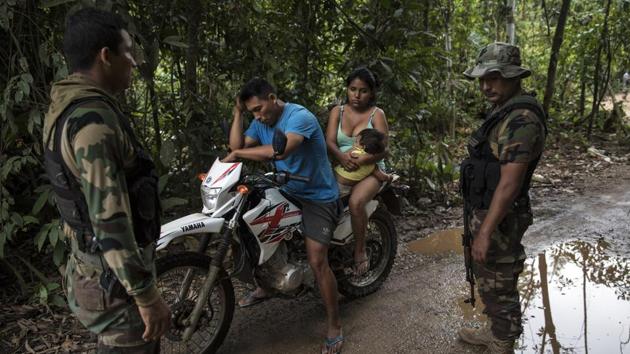 Policemen question a miner near the Mega 12 police base. They regularly patrol in vehicles and on motorcycles, though some miners emerge at night and there are concerns that others will wait for the military presence to subside, or simply relocate to more remote areas. (Rodrigo Abd / AP) Policemen question a miner near the Mega 12 police base. They regularly patrol in vehicles and on motorcycles, though some miners emerge at night and there are concerns that others will wait for the military presence to subside, or simply relocate to more remote areas. (Rodrigo Abd / AP)