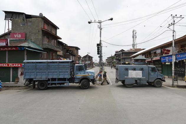 Paramilitary vehicles and personnel stand along a barricade during restrictions in the downtown area of Srinagar, Jammu and Kashmir, India on May 17, 2019. A complete shutdown is being observed in Kashmir following a separatist’s call for it against the recent killings in Kashmir(Waseem Andrabi/ Hindustan Times)