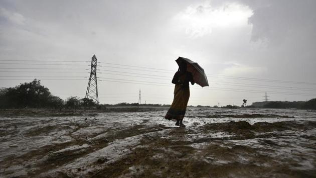 A woman walks with an umbrella in an open field during sudden rain in New Delhi. (Biplov Bhuyan / HT Photo) A woman walks with an umbrella in an open field during sudden rain in New Delhi. (Biplov Bhuyan / HT Photo)