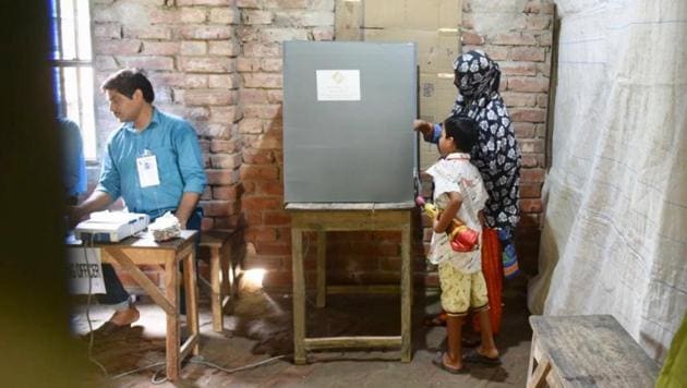 A woman casting her vote as her son looks in during the last phase of Lok Sabha poll at Banganagar in Diamond Harbour constituency , West Bengal on Sunday.(Photo: Arijit Sen/Hindustan Times)