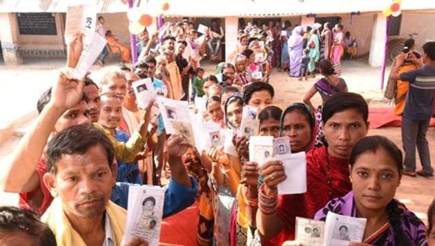 Voters show their identity cards as they stand in queues to cast their votes in Odisha.(Arabinda Mahapatra / HT PHOTO)