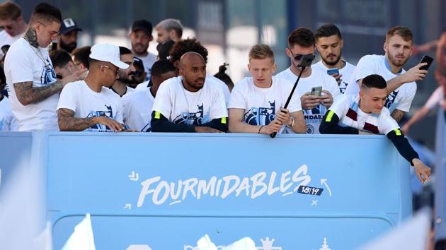 Manchester City players, including Manchester City's Brazilian goalkeeper Ederson (L) and Manchester City's English midfielder Fabian Delph (C), Manchester City's Ukrainian midfielder Oleksandr Zinchenko (center R) and Manchester City's English midfielder Phil Foden (R) take part in an open-top bus parade through Manchester(AFP)