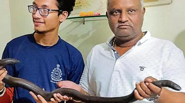 Officials with the rescued red sand boa, a protected species.(HTFile)