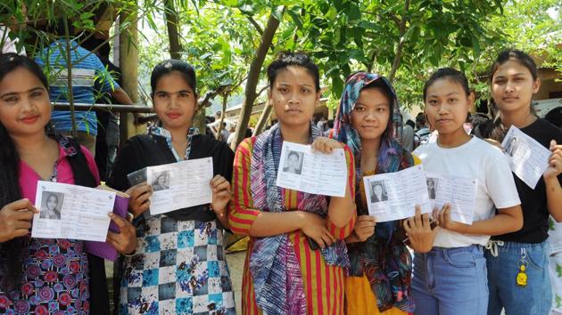 Voters standing in a queue and showing their ID cards during Lok Sabha Election 2019 in Guwahati.(ANI)