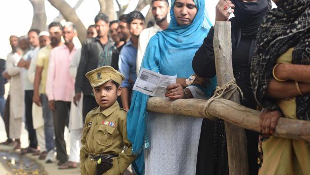 Uttar Pradesh, the state with 80 constituencies -- the maximum among all the others – witnessed polling in multiple phases. During the inaugural phase on April 11, a boy was seen dressed as a defence personnel while people queued to cast their votes at Sawal village. (Raj K Raj / HT Photo) 