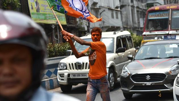 Bharatiya Janata Party (BJP) supporter seen with the party flag celebrates the lead of the party in the Lok Sabha election results, at BJP headquarters, in Kolkata, West Bengal, India.(Arijit Sen/HT Photo)
