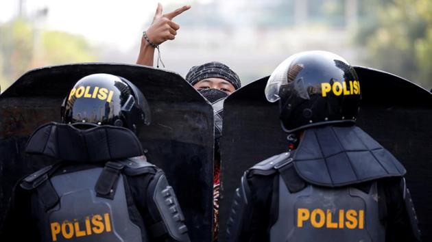 A protester gestures as mobile brigade police officers stand guard at a barricade during a protest near the Election Supervisory Agency headquarters in Jakarta, Indonesia. Protests rocked the Indonesian capital after clashes between security forces and protesters angry about the outcome of last month’s election, which handed President Joko Widodo a second term. (Willy Kurniawan / REUTERS)