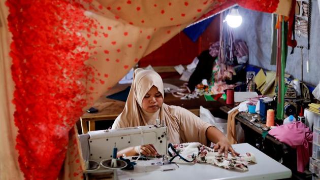 Asnia Muloc Sandiman, 25, works with a sewing machine provided by the government, in her family’s tent at an evacuation camp for families displaced by the siege. Sandiman sews made-to-order clothing and sells them online. “My deepest hope is that we are allowed to go back to Marawi but honestly, I would take any permanent address just to get out of here,” Sandiman said. (Eloisa Lopez / REUTERS) Asnia Muloc Sandiman, 25, works with a sewing machine provided by the government, in her family’s tent at an evacuation camp for families displaced by the siege. Sandiman sews made-to-order clothing and sells them online. “My deepest hope is that we are allowed to go back to Marawi but honestly, I would take any permanent address just to get out of here,” Sandiman said. (Eloisa Lopez / REUTERS)