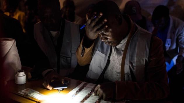 A Malawi Electoral Commission official goes through voters lists at Admark polling station during the Malawi Tripartite general elections in Mzuzu, Malawi. (Patrick Meinhardt / AFP)