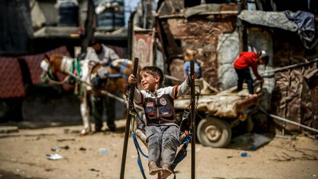 A Palestinian boy rides on a makeshift swing in an impoverished area in Beit Lahia in the northern Gaza Strip. (Mohammed Abed / AFP)