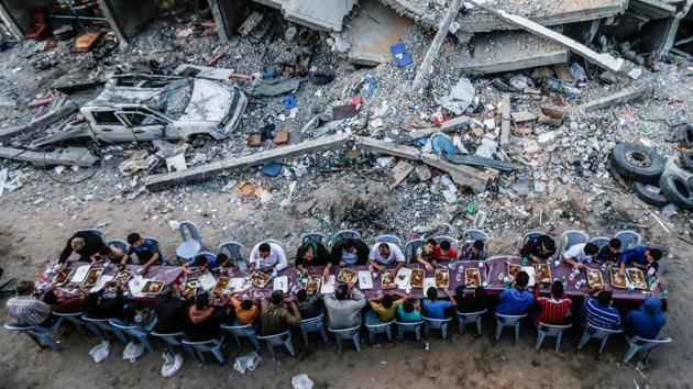 Palestinian families break their fast next to a destroyed building during recent confrontation between Hamas and Israel, in Gaza Strip, during the Muslim holy fasting month of Ramzan. (Mahmud Hams / AFP)