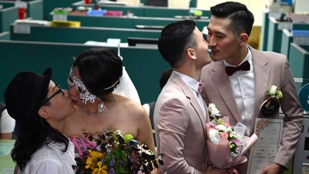 Taiwanese same-sex couples Shane Lin (2nd-R) and Marc Yuan kiss as another couple Cynical Chick (L) kisses Li Ying-Chien after registering at the Household Registration Office in Shinyi District in Taipei, Taiwan. Taiwan this week became the first place in Asia to legalise same-sex marriage, with a new law taking effect on Friday. (Sam Yeh / AFP)