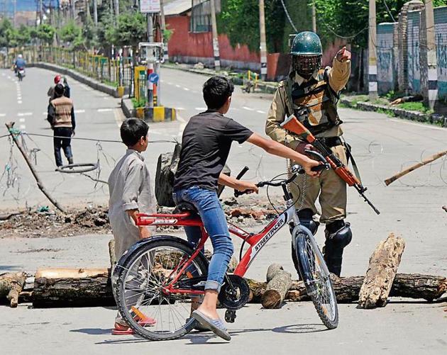 A soldier diverts children from a barricade in downtown Srinagar on Saturday.(Photo: Waseem Andrabi /HT)