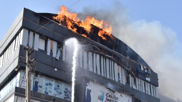 Fire brigade douses Takshashila Arcade blazing in fire after a fire broke out on the top floor of a building in Surat on Friday.(ANI photo) Fire brigade douses Takshashila Arcade blazing in fire after a fire broke out on the top floor of a building in Surat on Friday.(ANI photo)