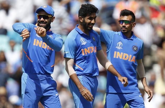 India's Jasprit Bumrah (C) celebrates with India's captain Virat Kohli (L) after taking the wicket of New Zealand's Colin Munro during the 2019 Cricket World Cup warm up match between India and New Zealand at The Oval in London (AFP)