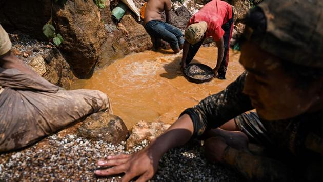 Team members haul buckets to muddy pools to clean away dirt, before sifting through piles of pebbles for a telltale red glint or other gemstones. Police have started patrolling some sites, sparking fears among hopeful prospectors that they will soon start cracking down on the operations. (Ye Aung Thu / AFP)
