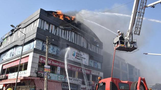 Firefighters work to douse a blaze at Takshila complex that engulfed the third and fourth floor of the coaching centre, in Surat, Gujarat. (HT Photo) Firefighters work to douse a blaze at Takshila complex that engulfed the third and fourth floor of the coaching centre, in Surat, Gujarat. (HT Photo)