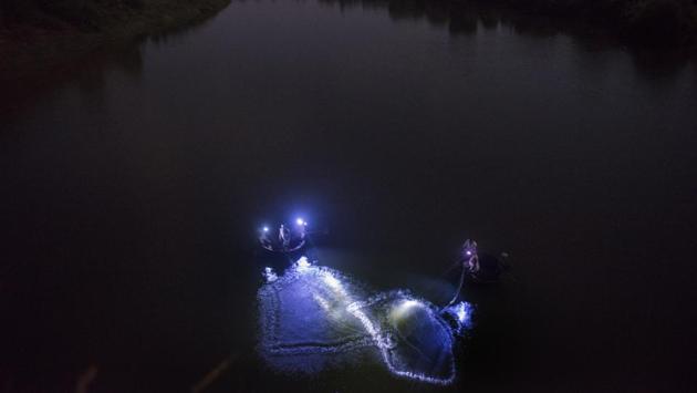 Fishermen from Bhilewadi out on their boats in the night, with heavy floodlights as a precautionary measure to avoid attacks from crocodiles, in Maharashtra. (Anshuman Poyrekar / HT Photo) Fishermen from Bhilewadi out on their boats in the night, with heavy floodlights as a precautionary measure to avoid attacks from crocodiles, in Maharashtra. (Anshuman Poyrekar / HT Photo)