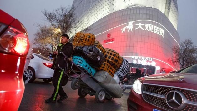 A deliveryman leans against a cart outside a wholesale market in central Zhengzhou. Considered the cradle of Chinese civilization, the central province of Henan and its 100 million-strong population symbolizes China’s transformative yet often turbulent economic ascent. (Thomas Peter / REUTERS) A deliveryman leans against a cart outside a wholesale market in central Zhengzhou. Considered the cradle of Chinese civilization, the central province of Henan and its 100 million-strong population symbolizes China’s transformative yet often turbulent economic ascent. (Thomas Peter / REUTERS)