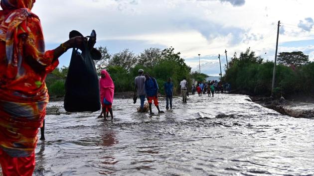 People wade across a submerged road following flash flooding in Isiolo. The text messages have also helped Samuel Lkiangis Lekorima protect not just his livestock, but the safety of his community. Harsher droughts have stoked intense competition between pastoralists for water and pasture. A feud between two groups over a watering hole near Ethiopia left 11 dead in May, local media reported. (Tony Karumba / AFP) People wade across a submerged road following flash flooding in Isiolo. The text messages have also helped Samuel Lkiangis Lekorima protect not just his livestock, but the safety of his community. Harsher droughts have stoked intense competition between pastoralists for water and pasture. A feud between two groups over a watering hole near Ethiopia left 11 dead in May, local media reported. (Tony Karumba / AFP)