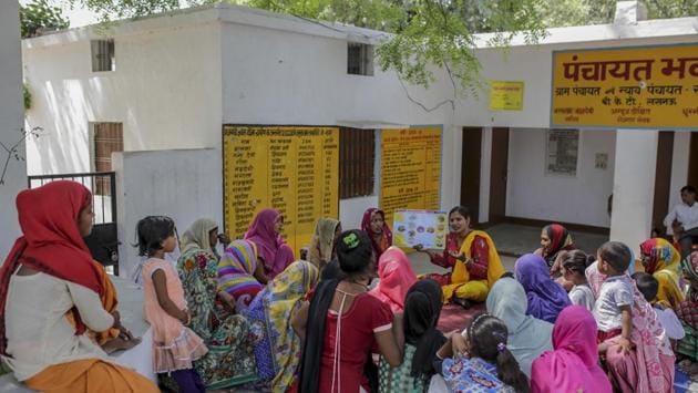 “What do you do when you are expecting guests in the house?” Anju Maurya (C, right), a block coordinator with WaterAid India and its partner asks a group of women of all ages under a shady tree in front of village Panchayat Office in Sonva, Bakshi Ka Talab block of Lucknow, Uttar Pradesh. “I prepare some nice food,” one lady pipes up. “I make sure my house is clean,” says another. (WaterAid / Dhiraj Singh)