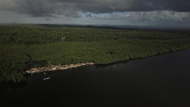 Jose is part of an unofficial community known as “The Train” because the mud houses, in the community where he lives, are arranged in single file along the edge of the Caratingui river like train cars. The low-lying island, otherwise covered in mangroves, is quickly receding under the water. (Nacho Doce / REUTERS) 