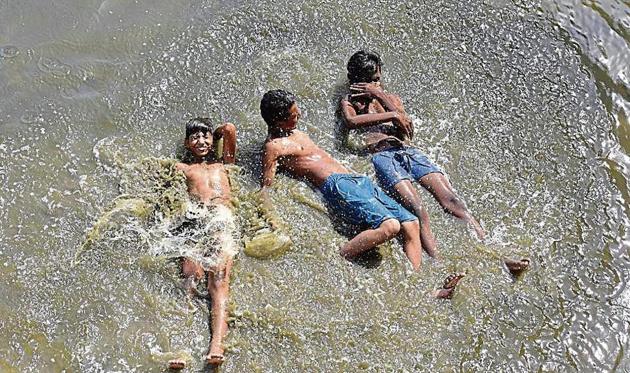 Children cool themselves off in the Yamuna on Wednesday. According to IMD, the heatwave will continue for at least a week with no respite in the form of pre-monsoon showers.(HT Photo/Virendra Singh)