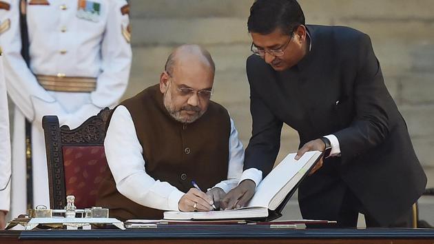 Bharatiya Janata Party (BJP) chief Amit Shah signs the documents after taking oath during a swearing-in ceremony, at the forecourt of Rashtrapati Bhavan in New Delhi, on Thursday, May 30, 2019.(Ajay Aggarwal/HT PHOTO)