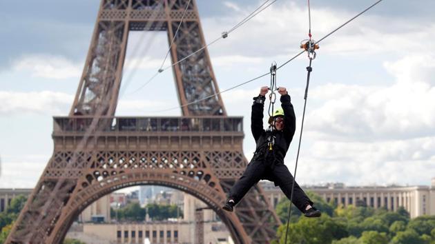 A participant rides a zip line from the second floor of the Eiffel Tower, 115 metres above the ground along an 800-metre long route, as part of the Smash Perrier free event in Paris, France. (Charles Platiau / REUTERS)