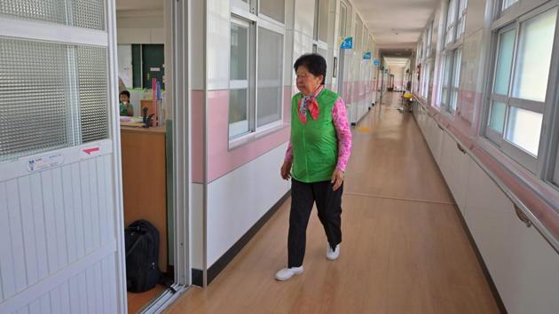 Nam Yang-soon walks into a classroom. Woldeung Elementary School typifies the phenomenon. At its peak in 1968, it had 1,200 pupils. Now just 29 children attend. Last year it faced having to combine its first- and second- year classes because of the lack of numbers, so offered places to local residents who had not previously gone to school. (Jung Yeon-je / AFP) 