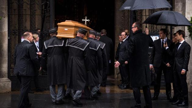 The coffin of Austrian three-time Formula One world champion Niki Lauda is carried into St. Stephen’s Cathedral in Vienna as his wife Birgit Wetzinger (2nd R) and sons Mathias (3rd R) and Lukas (R) attend, before the funeral service. (Vladimir Simicek / AFP)