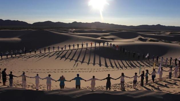 People attend a yoga class during a meeting organized by the YSYoga System community in the Samalayuca Dune Fields in the municipality of Juarez, Chihuahua State, Mexico. (Herika Martinez / AFP)