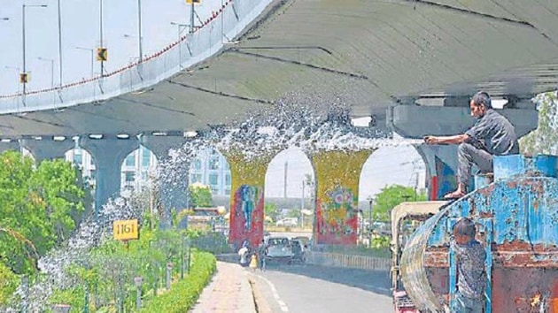 A worker sprays water on plants at Hindon road on Saturday. According to officials, geo-tagging process is to be undertaken before and after the plantation drives in August in Ghaziabad. (Sakib Ali/HT Photo) A worker sprays water on plants at Hindon road on Saturday. According to officials, geo-tagging process is to be undertaken before and after the plantation drives in August in Ghaziabad. (Sakib Ali/HT Photo)