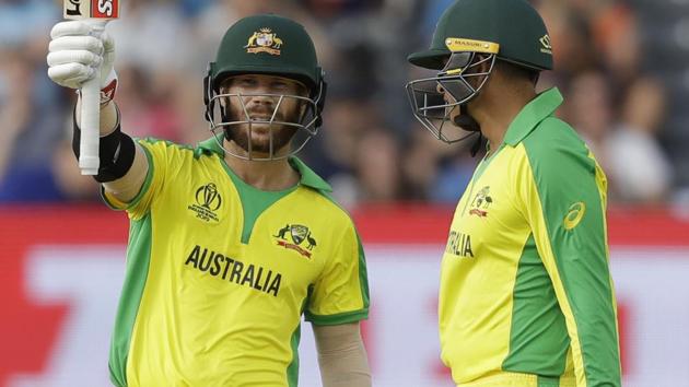 Australia's David Warner celebrates reaching 50 runs next to Australia's Usman Khawaja, right. (AP)