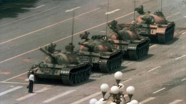 A Chinese man stands alone to block tank convoy leaving Tiananmen Square on June 5, 1989 in a minutes-long standoff before two men pulled him away. Captured on camera, the “Tank Man” image spread around the world as a symbol of defiance against the crackdown and one of the defining images of the 20th century. The man’s identity and fate are unknown. (Jeff Widener / AP File)