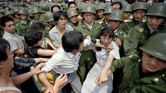 A young woman is caught between civilians and soldiers trying to remove her from an assembly on June 3, 1989. Frustrated by government indifference and the potential consequences of the April editorial, student leaders launched a hunger strike to demand dialogue with the nation’s leaders and recognition of their movement as patriotic and democratic. A May 18 meeting with Premier Li Peng was contentious. (Jeff Widener / AP File)
